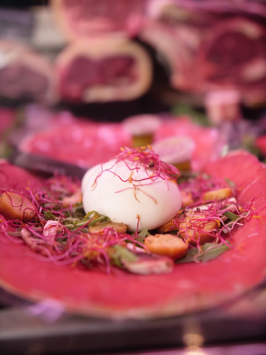 Assiette de burrata sur fines tranches de viande, préparée à la boutique